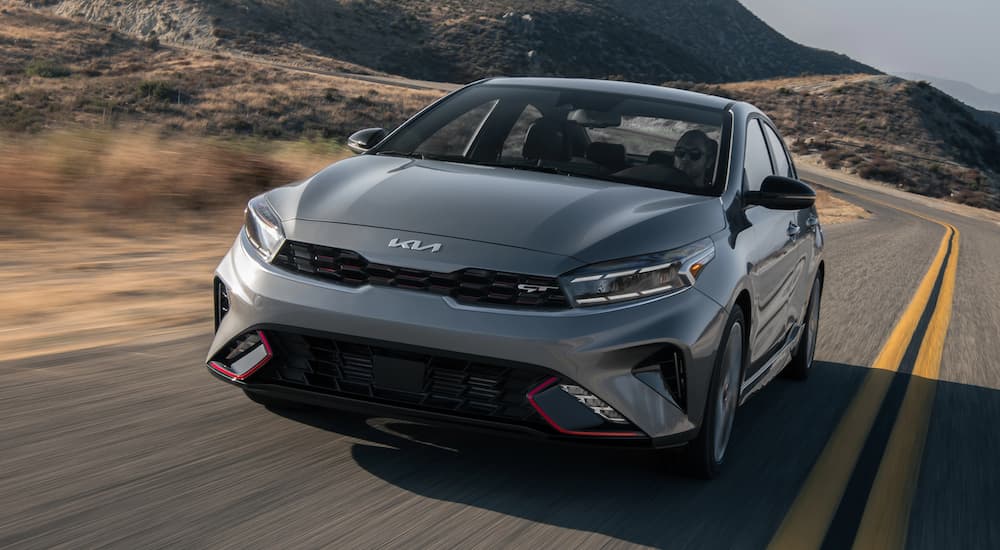 A grey 2022 Kia Forte GT is shown driving on desert road.