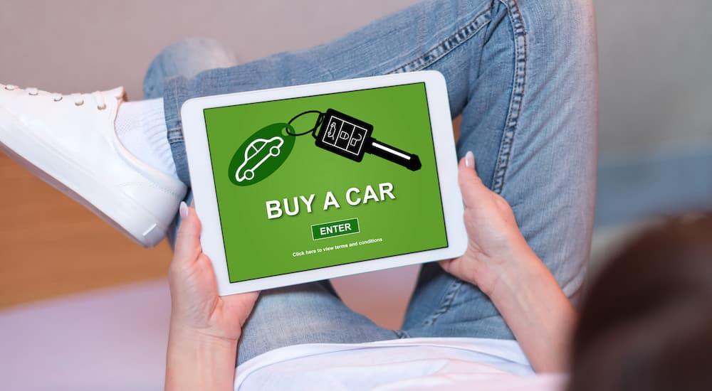 A tablet is shown being used to buy a car online.