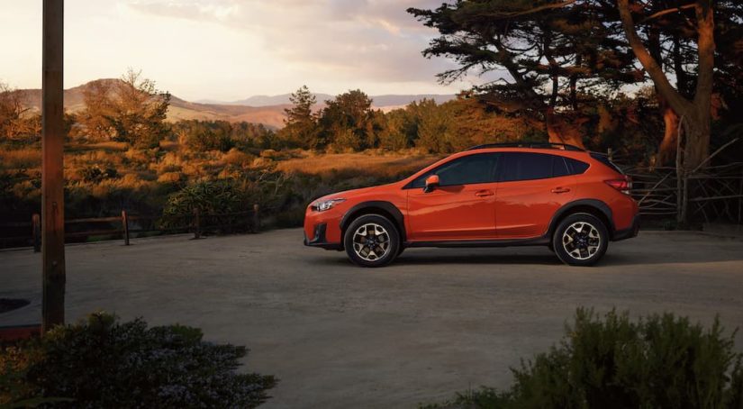 An orange 2020 Subaru Crosstrek Premium is shown from the side in a dirt lot.