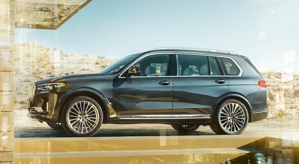 A grey 2020 BMW X7 is shown from the side parked in a driveway.