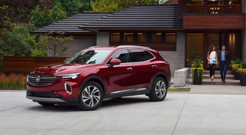 A red 2022 Buick Envision is shown parked outside of a modern home.