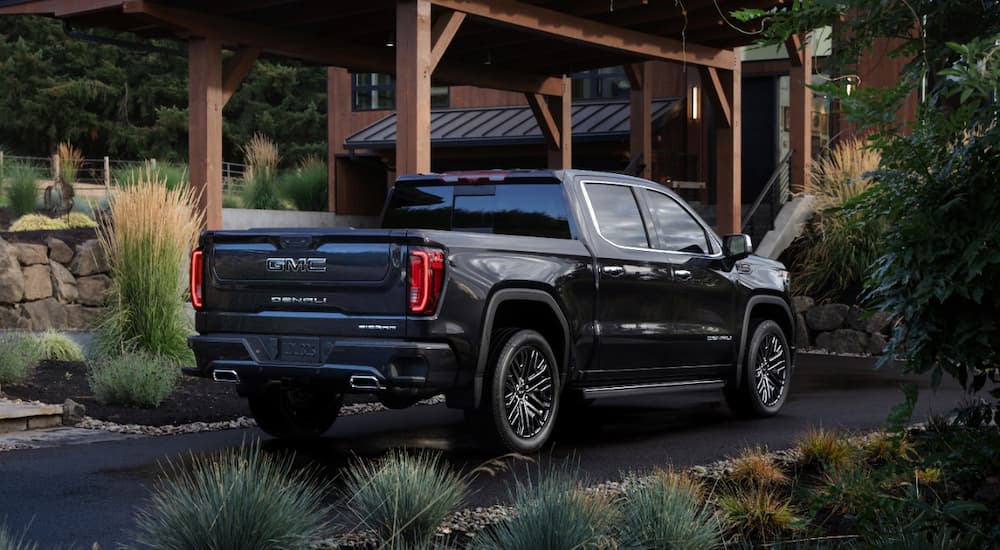 A black 2022 GMC Sierra Denali Ultimate is shown from the rear parked in a driveway.