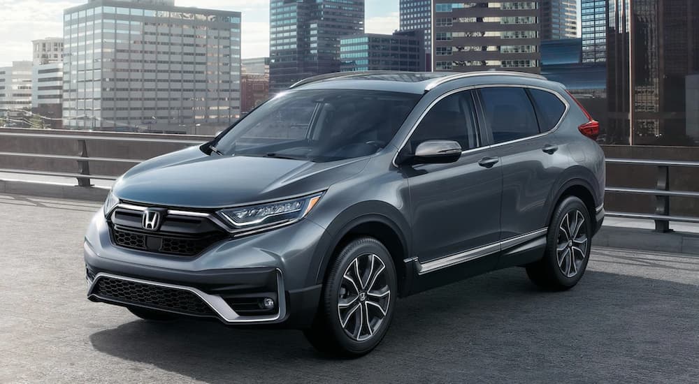 A grey 2022 Honda CR-V Touring is shown in a city rooftop parking lot.