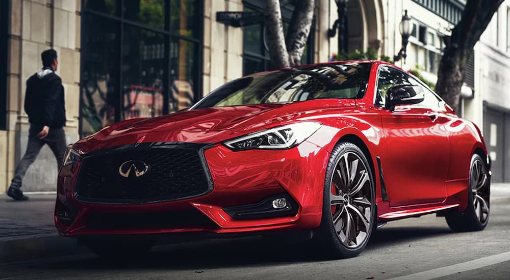 A red 2022 Infiniti Q60 is shown parked on the side of a city street.