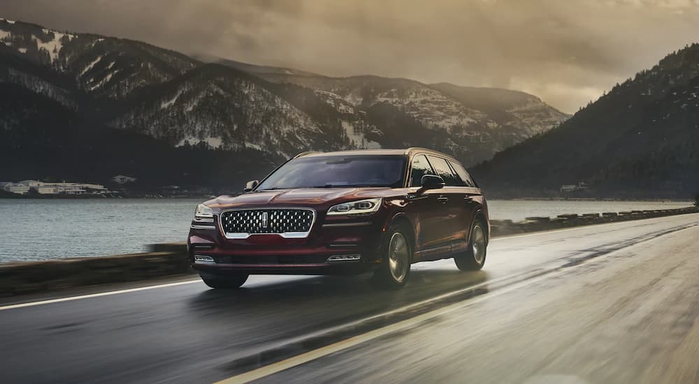A red 2022 Lincoln Aviator is shown driving on an open road.