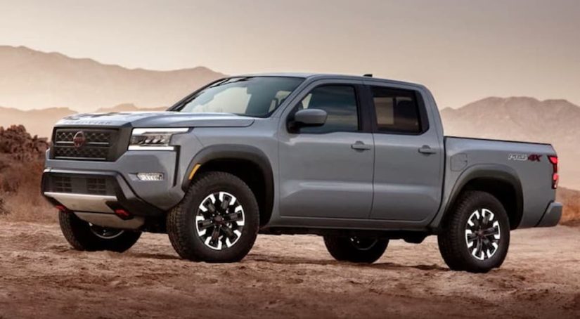 A grey 2022 Nissan Frontier Pro-4x is shown from the side while parked in the desert after leaving a used Nissan dealership.