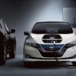 A white 2022 Nissan Leaf is shown charging in a garage.