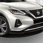 A white 2022 Nissan Murano is show parked on a light city backdrop.