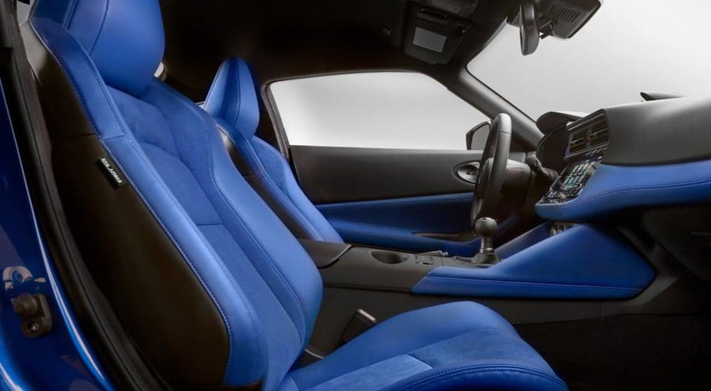 The blue interior of a 2023 Nissan Z is shown from the passenger side door.