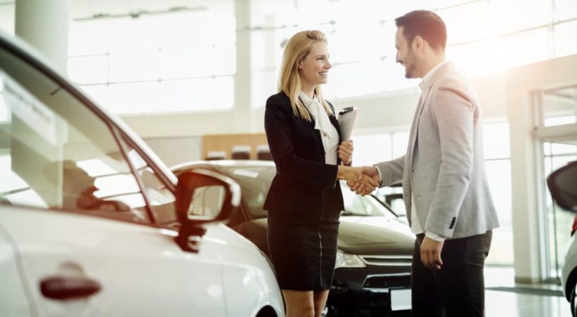 A saleswoman is shown speaking to a customer about car loans.