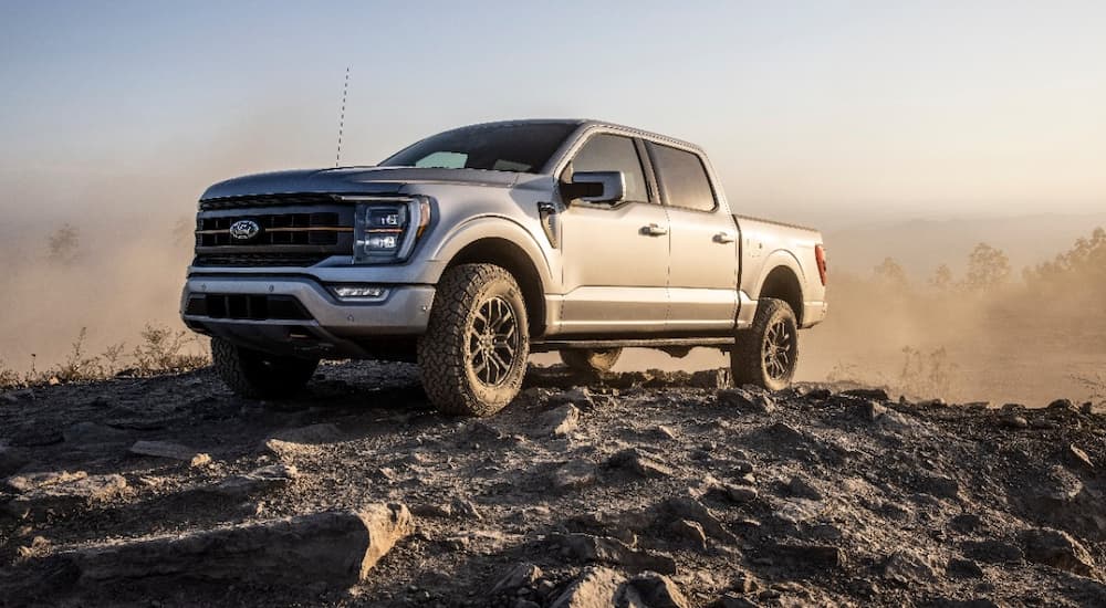 A silver 2022 Ford F-150 Tremor is shown off-roading on a rocky trail.