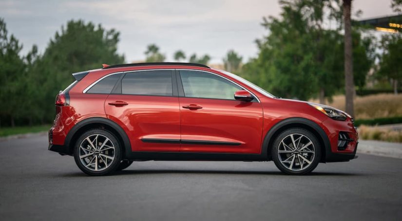 A red 2022 Kia Niro is shown from the side after leaving a Kia dealer.