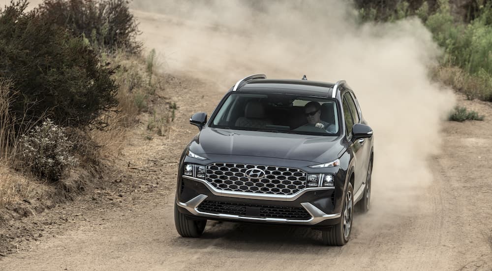 A grey 2022 Hyundai Santa Fe is shown from the front going down a dirt road after leaving a Hyundai dealer near you.