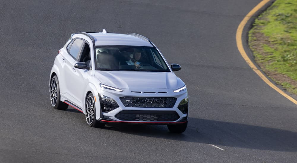 A white 2022 Hyundai Kona N is shown from the front while it takes a corner on a track.