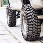 The side and tires of a white lifted truck is shown.