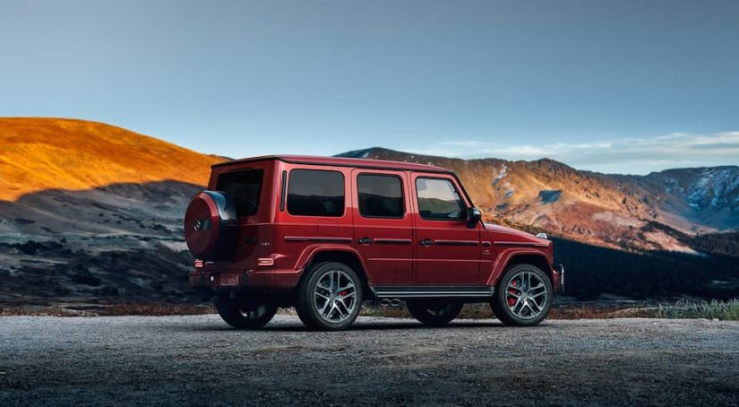 A red 2021 Mercedes AMG G 63 is shown from the side in the mountains.