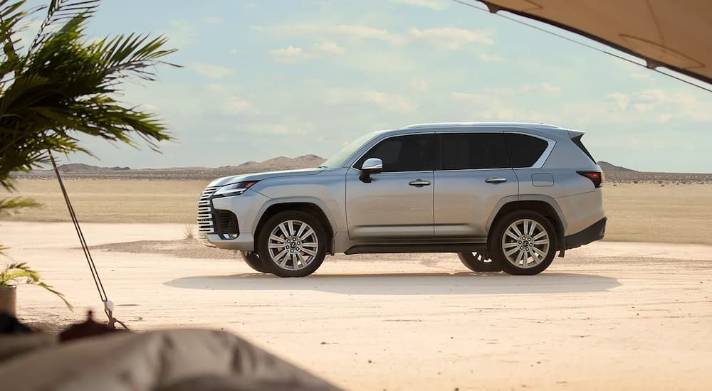 A silver 2022 Lexus LX 600 is shown outside a tent while parked in the desert.