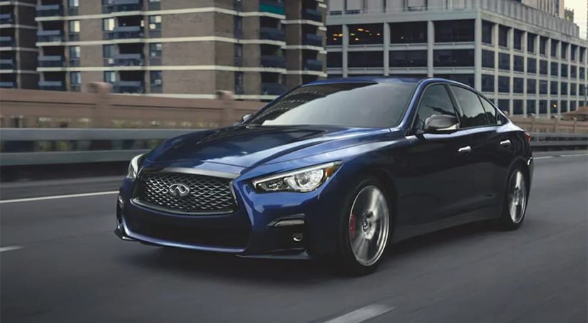 A blue 2021 Infiniti Q50 is shown in a city after visiting a online car dealership.