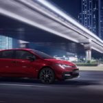 A red 2022 Toyota Corolla SE Nightshade Edition is shown driving on a city street.