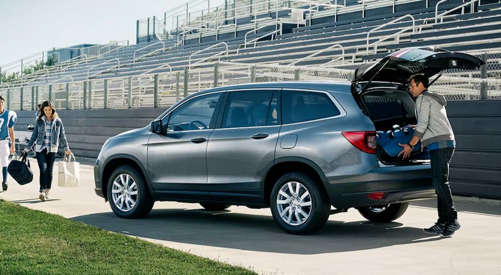 A silver 2020 Honda Pilot is shown at a game stadium after viewing certified Hondas for sale.