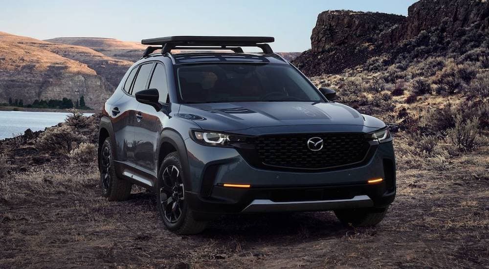 A grey 2022 Mazda CX-50 is shown from the front at an angle while parked off-road.