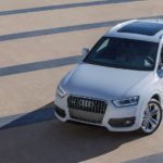 A white 2015 Audi Q3 is shown parked in a lot of an online car dealer.
