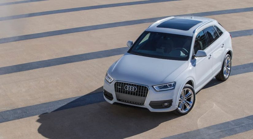 A white 2015 Audi Q3 is shown parked in a lot of an online car dealer.