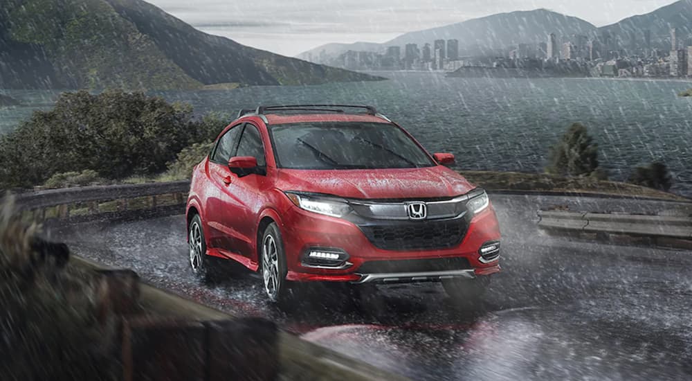 A red 2020 Honda HR-V is shown from the front at an angle while it drives through the rain.