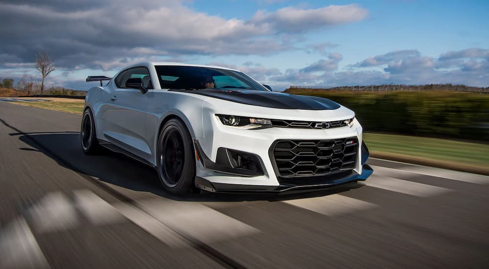 A white 2022 Chevy Camaro ZL1 is shown driving on a track.