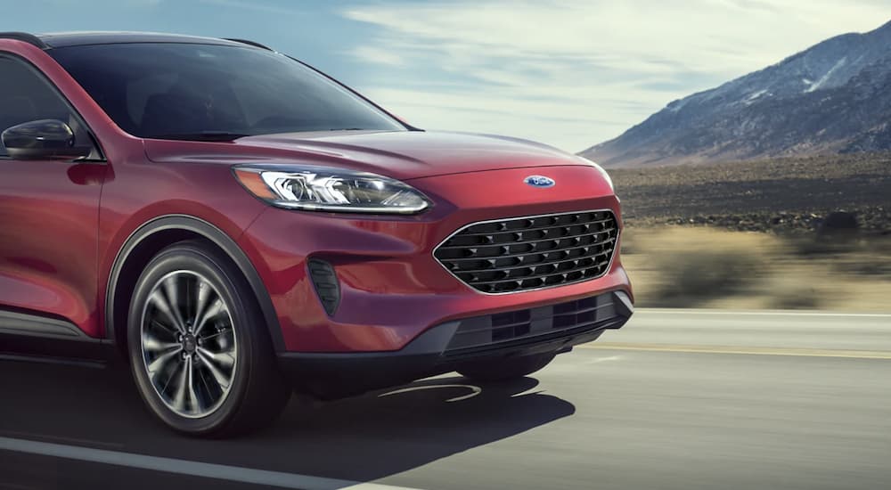 A red 2022 Ford Escape is shown from the side driving on an open road.