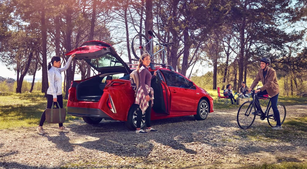 A red 2022 Toyota Prius Prime is shown at a park.