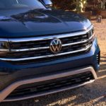 A close up of the hood of a blue 2022 Volkswagen Atlas is shown in a driveway.
