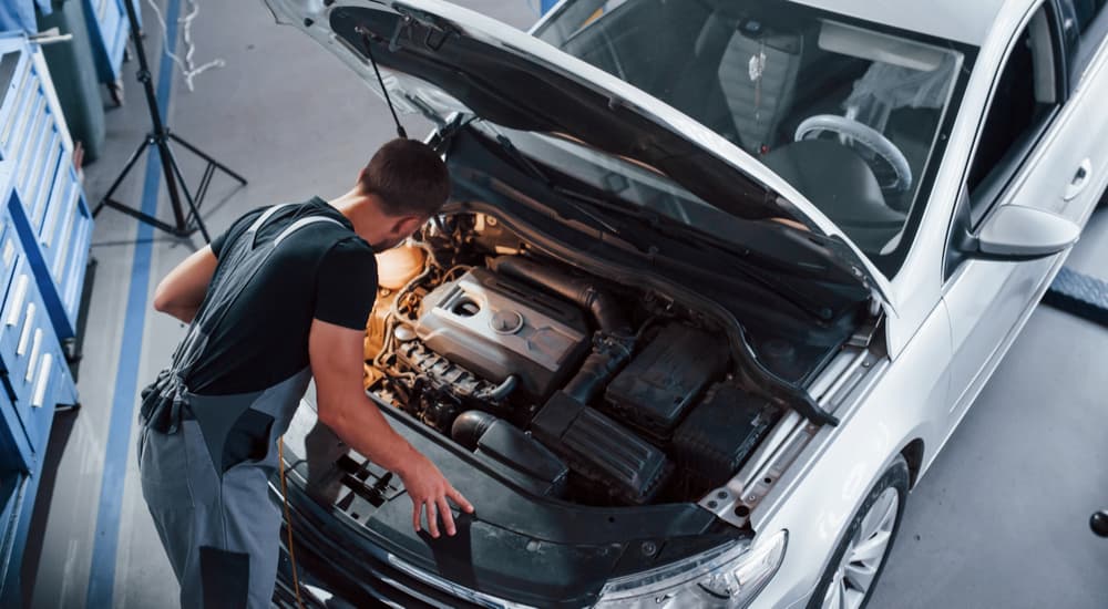 A mechanic is shown inspecting a certified pre-owned vehicle.