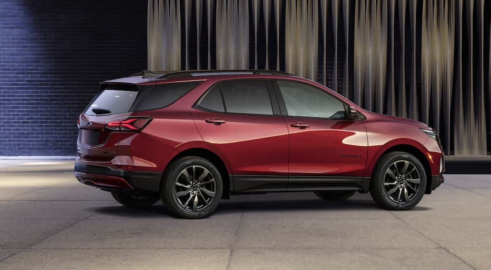 A red 2022 Chevy Equinox is shown from the side parked at a Chevy dealer.
