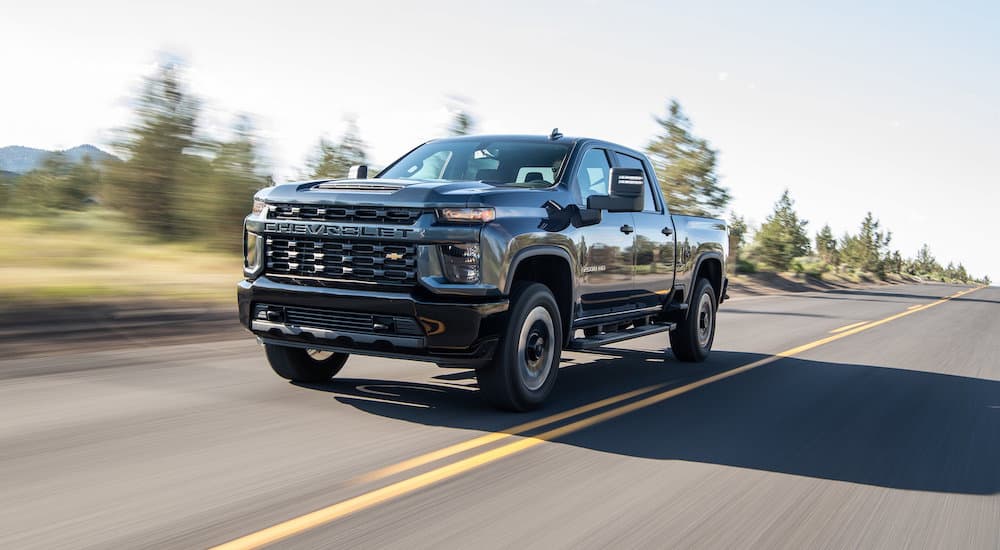 A grey 2022 Chevy Silverado 2500HD is shown from the front at an angle while it drives down the road.