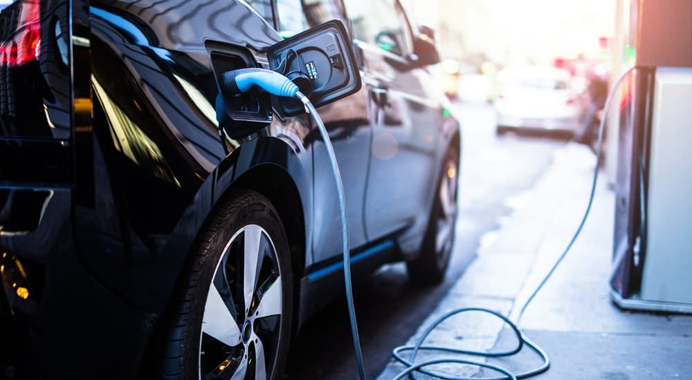 A black vehicle is shown parked at a charging station by an EV dealership near you.