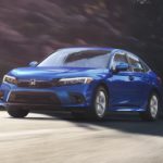 A blue 2022 Honda Civic LX is shown from the front driving on an open road.