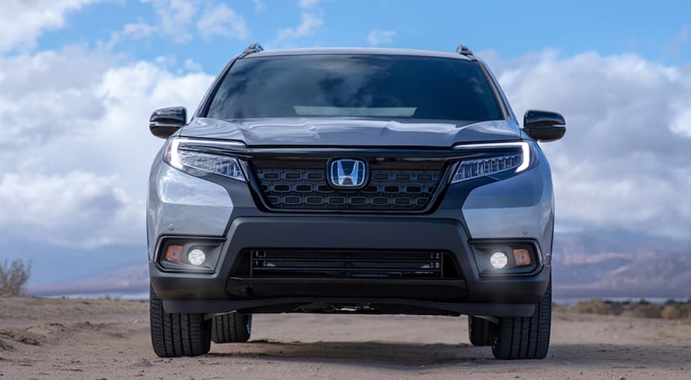 A silver 2021 Honda Passport Elite is shown from the front while parked in the desert.