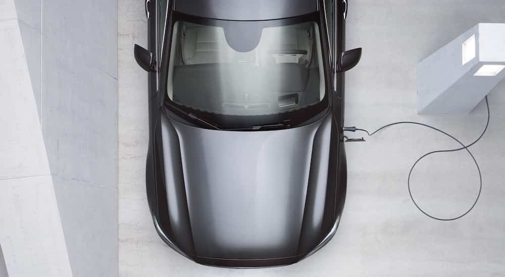 A grey 2022 Volvo S60 Recharge is shown from above at a charger.