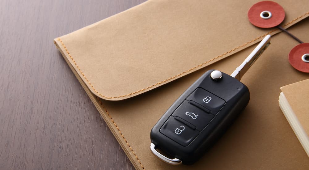 A car key is shown sitting on top of an envelope.