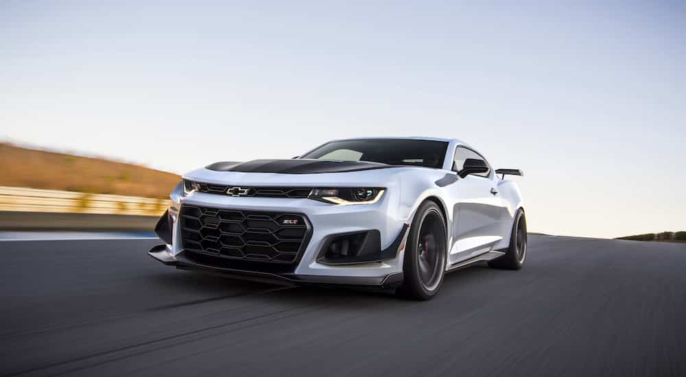 A white 2022 Chevy Camaro ZL1 1LE is shown from the front at an angle while on a racetrack.