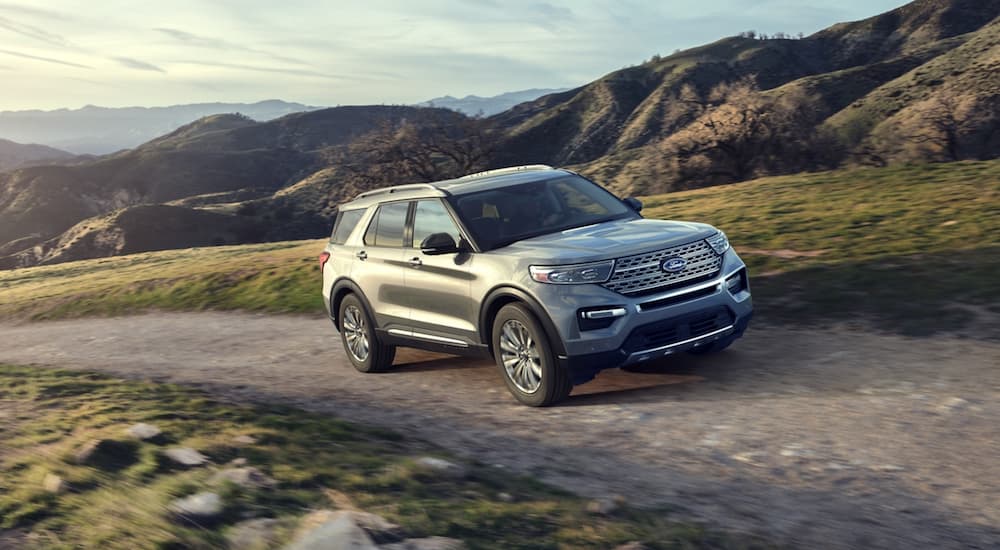 A silver 2022 Ford Explorer is shown from the front at an angle while driving down a dirt path.