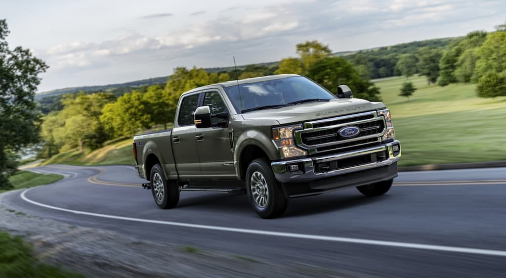 A green 2020 Ford F-250 is shown from the front while driving down the road.