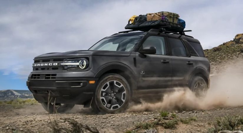 A dark gray 2022 Ford Bronco Sport Outer Banks is shown from the front at an angle while loaded with camping equipment.