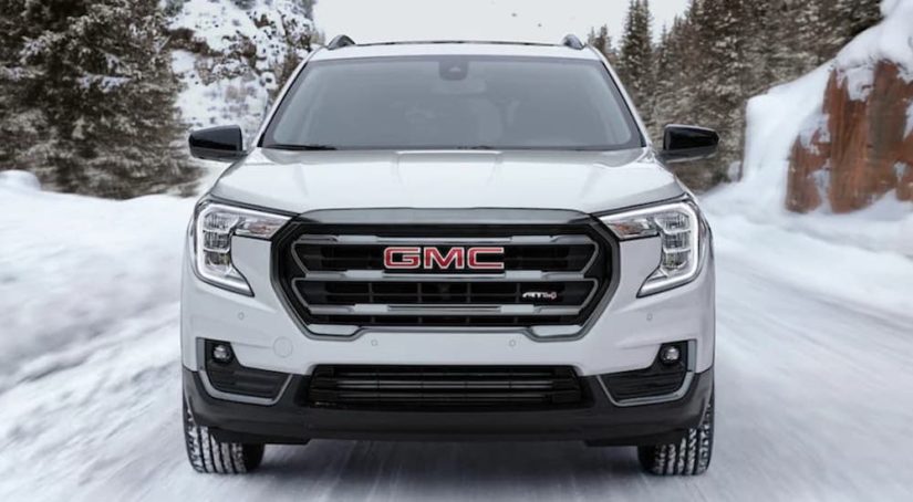A white 2022 GMC Terrain AT4 is shown from the front in the snow during a 2022 GMC Terrain vs 2022 Mitsubishi Eclipse Cross comparison.