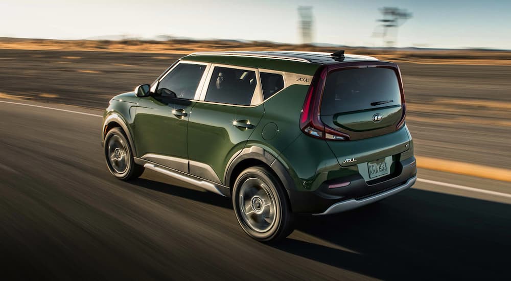 A green 2022 Kia Soul is shown from the rear while driving down the road.