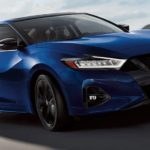 A blue 2021 Nissan Maxima is shown from the front at an angle after leaving a Nissan dealer.