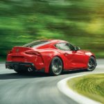 A red 2021 Toyota Supra is shown from the rear while rounding a corner.