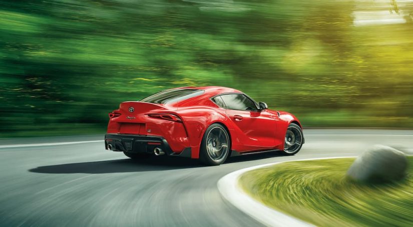 A red 2021 Toyota Supra is shown from the rear while rounding a corner.