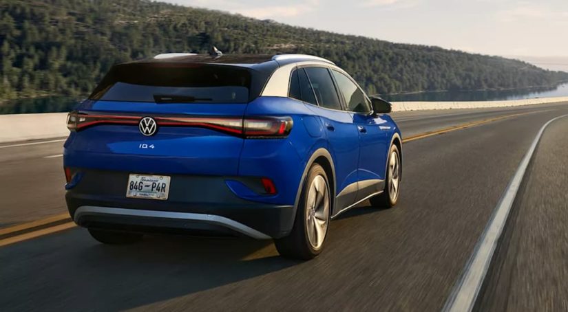 A blue 2022 Volkswagen ID.4 electric vehicle is shown from the rear while it drives down the highway.